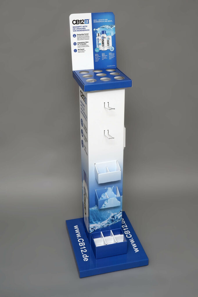 Schlanker Bodendisplay in weiß-blau mit neun runden Aussparungen für Flaschen an der Oberseite und zusätzlichen Fächern an der Vorderseite für CB12, produziert von pod GmbH