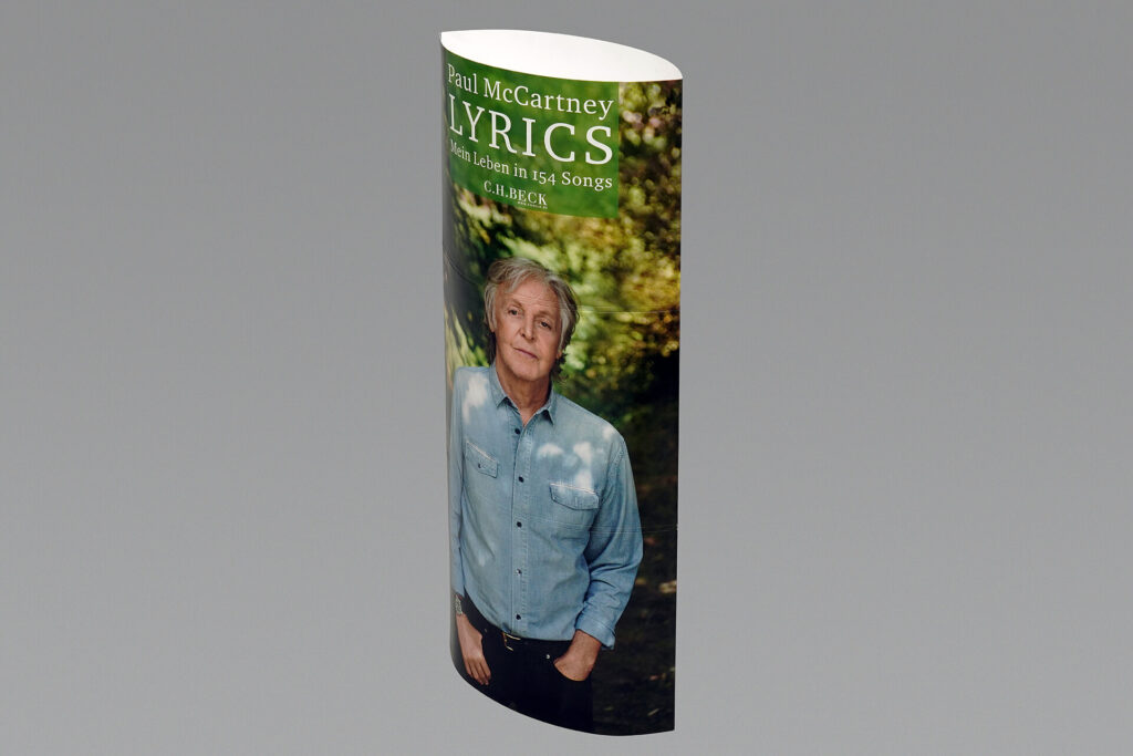 Säulendisplay von pod GmbH mit einem Foto von Paul McCartney und der Aufschrift "Lyrics - Mein leben in 154 Songs"