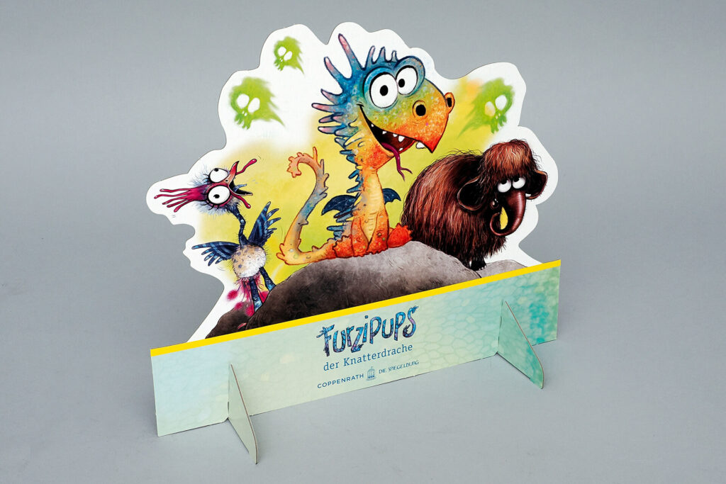 Standfigur von pod GmbH mit einer Abbildung des Knatterdrachen Furzipups vom Coppenrath Verlag