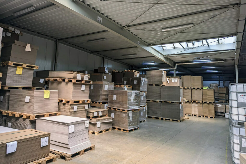 pod GmbH Services: Mehrere mit flachen Kartons beladene Paletten in der Lagerhalle